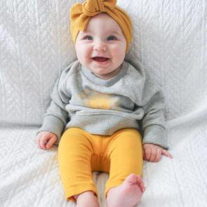 Baby sitting and smiling. Photo by Kristina Paparo