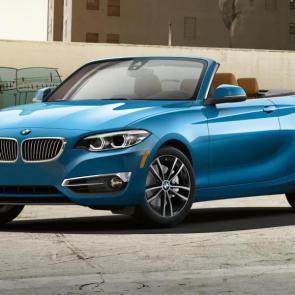 A front angle view of the BMW 230i Convertible in Seaside Blue Metallic.