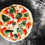 pizza with green leaf vegetable Photo by Inna Podolska on Unsplash 