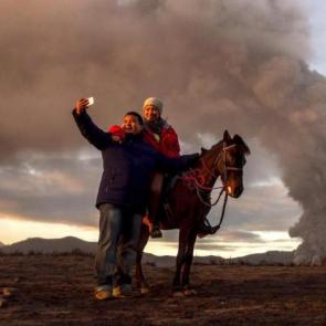 زوج توریست در حال گرفتن سلفی در کنار آتشفشان کوه Bromo spews در شمال جاوا ، اندونزی / Photograph: Fully Handoko/EPA