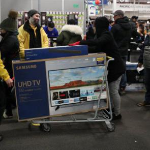 People leave with their bargains from Best Buy in Westbury, New York (Picture: Reuters)